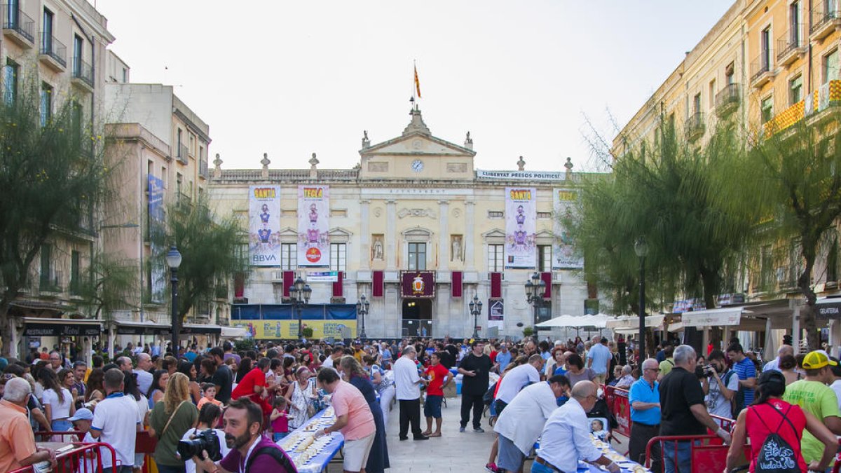Centenars de persones van fer cua a la plaça de la Font per poder degustar el pastís.