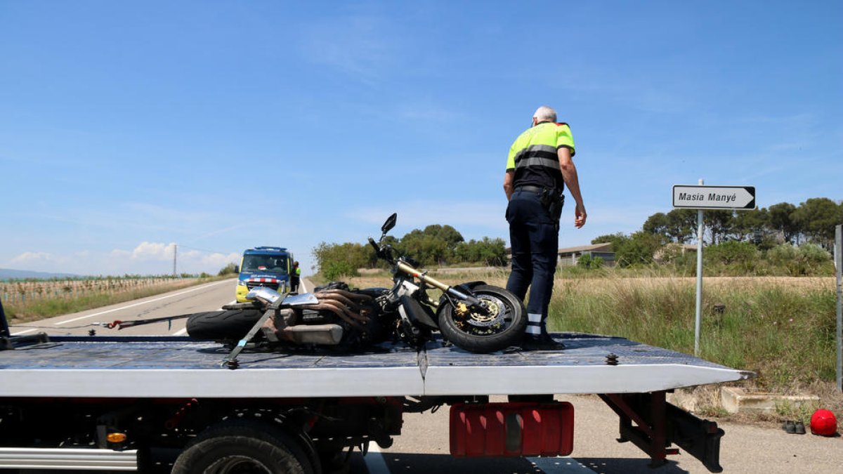 Un operari de la grua retira la moto sinistrada en un accident mortal a l'entrada a Nulles (Alt Camp).
