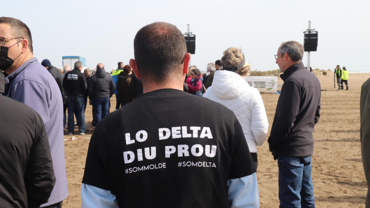 Un assistent a l'acte organitzat pel MOLDE a la platja del Trabucador llueix una samarreta en defensa del Delta.