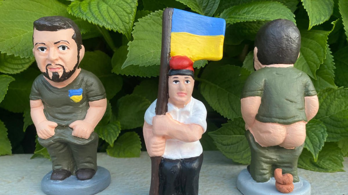 Una figura del caganer de Volodimir Zelenski i del caganer pagès amb una bandera d'Ucraïna.