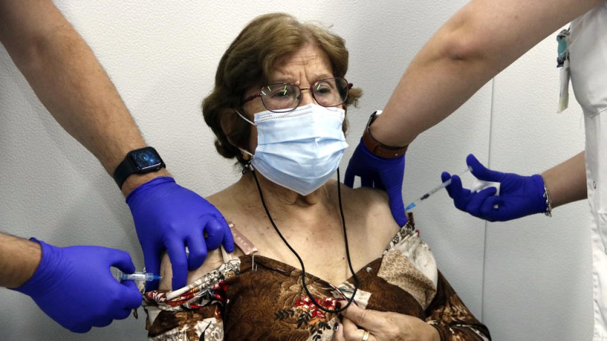 Una senyora major de 70 anys rep, simultàniament, la vacuna de la grip i la tercera dosi de la covid.
