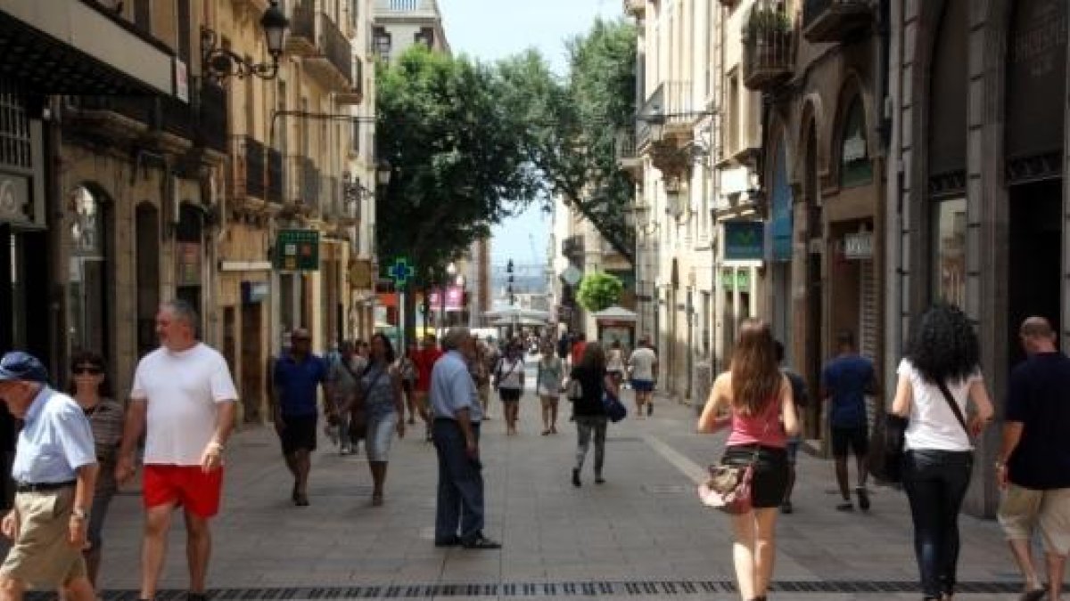 Pla general de gent passejant i comprant en un carrer de Tarragona.