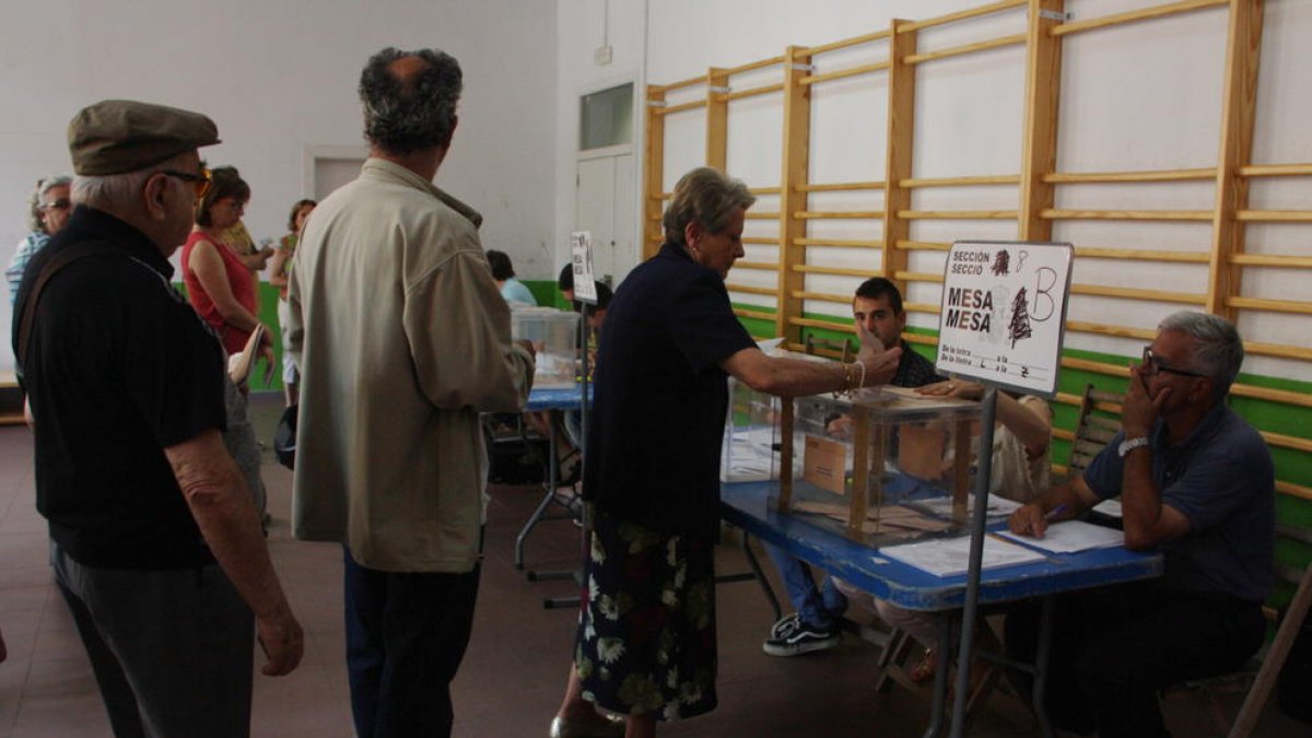 Tres electores hacen cola ante la mesa electoral en el colegio de IES Tarragona de Tarragona el 26 de junio de 2016