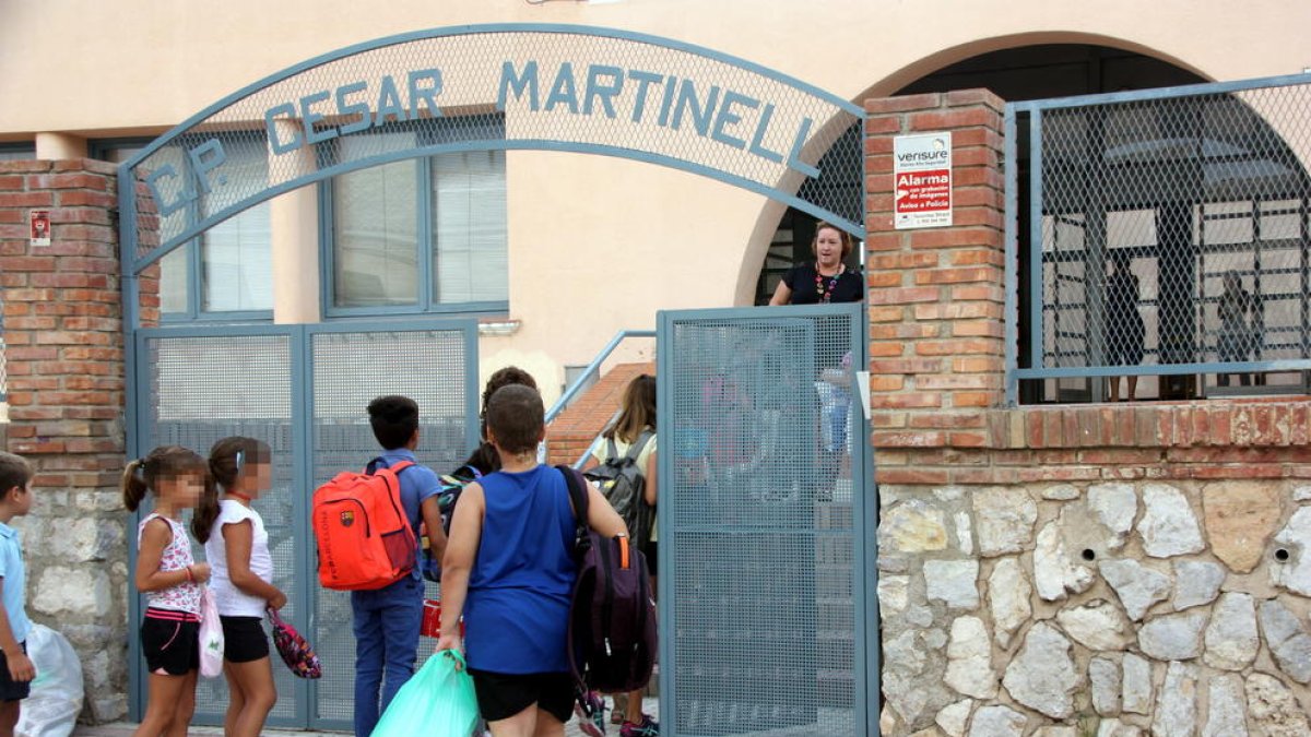 Els pocs alumnes que han anar a l'escola el segon dia de curs al Pinell de Brau fent cua per entrar. Imatge del 13 de setembre de 2016 (horitzontal)