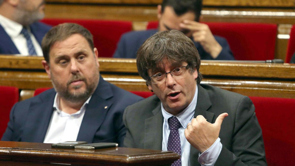 Carles Puigdemont i Oriol Junuers durant el debat parlamentari d'aquest dijous.