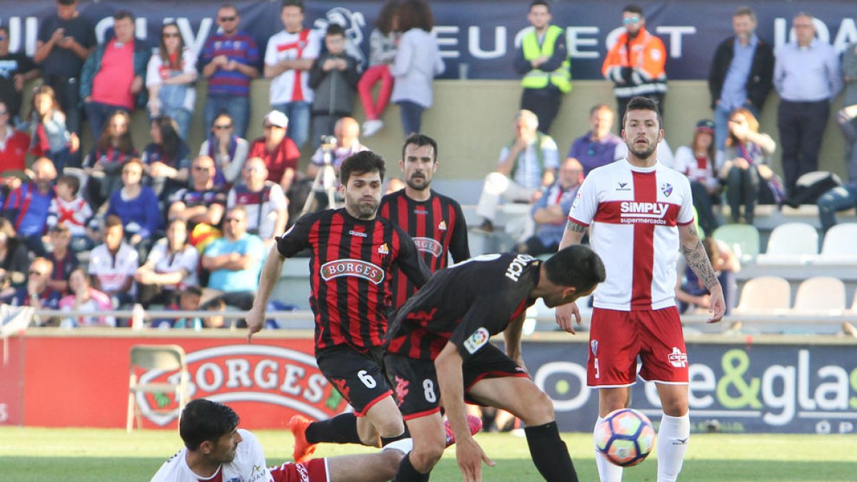 El capità Ramon Floch, en primer terme, durant un instant del partit contra l'Osca, sota la mirada dels també roig-i-negres Vítor Silva i Aritz López Garai.