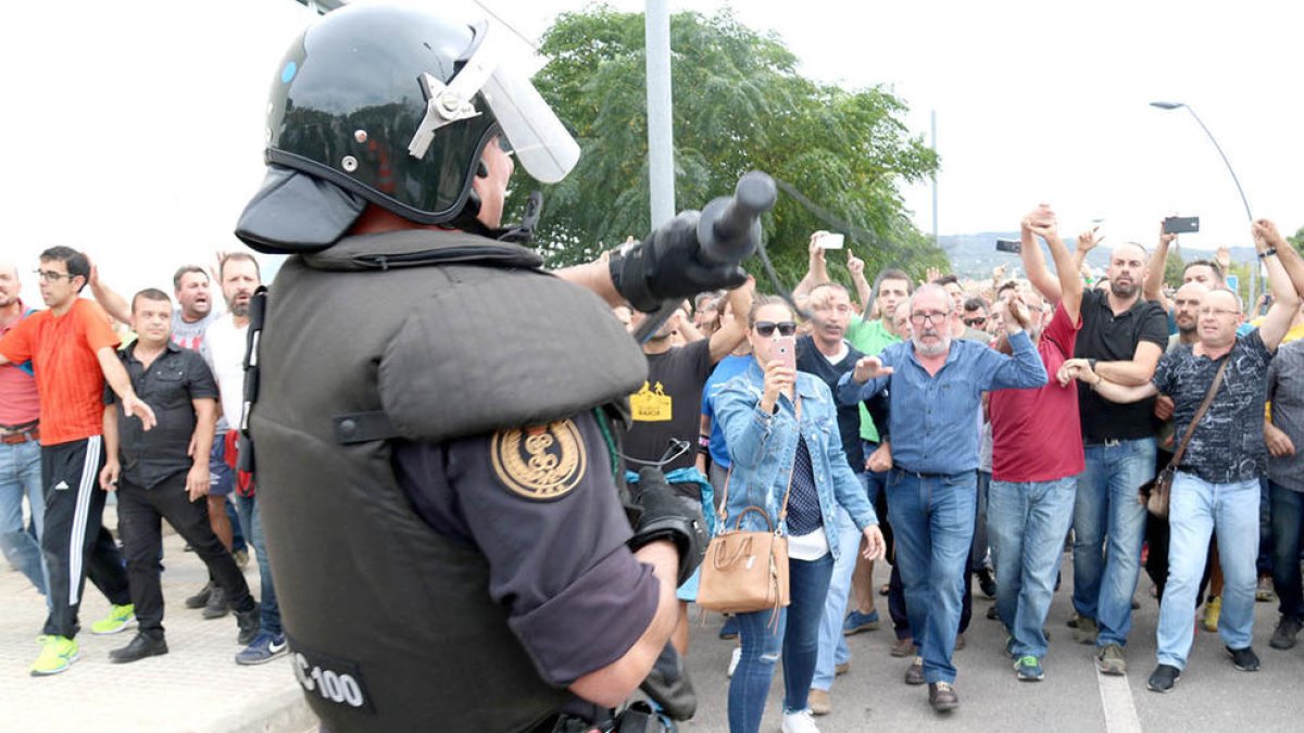 Un dels agents de la Guàrdia Civil ensenyant la porra als ciutadans que els increpaven per la seva actuació a Roquetes