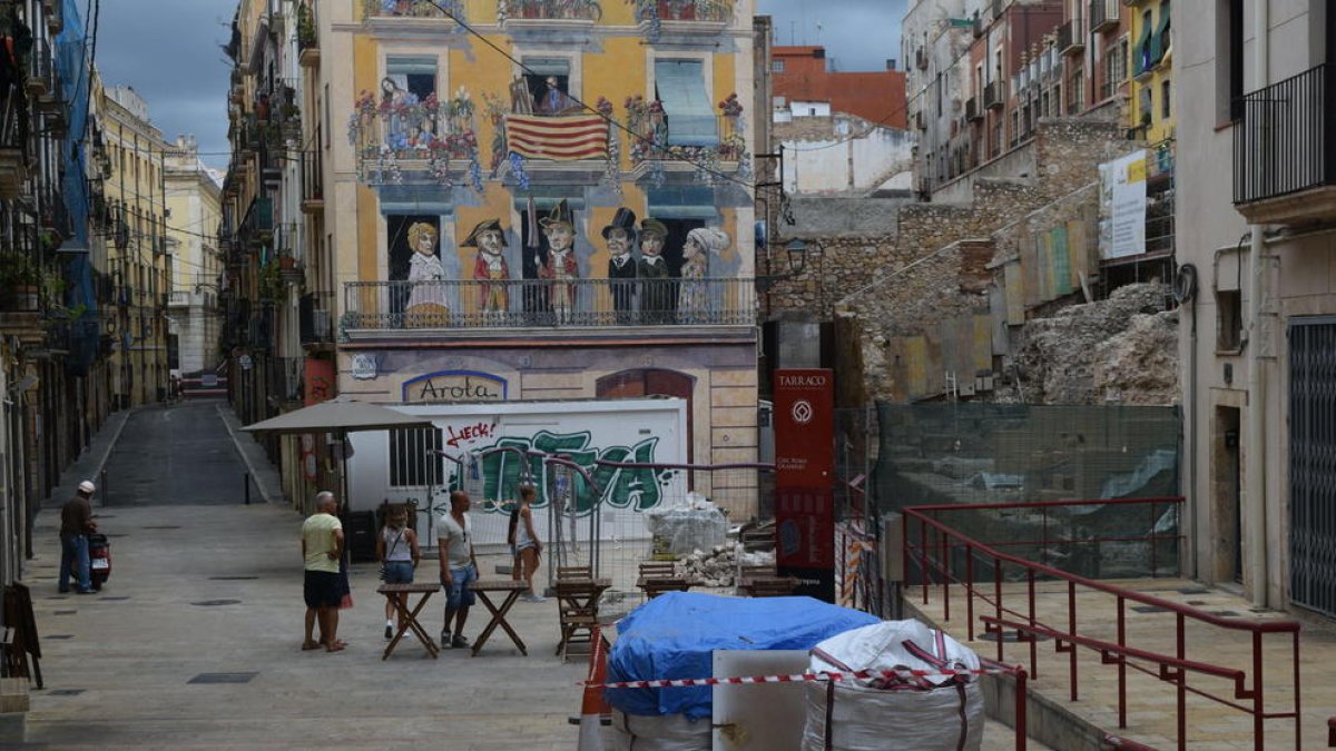 Imatge de la plaça dels Sedassos buida, amb un grup de turistes observant les obres del Circ.