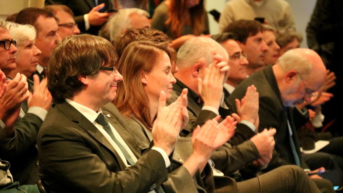 El president Puigdemont y la consellera Serret aplauden durante el acto con los alcaldes de Bruselas.