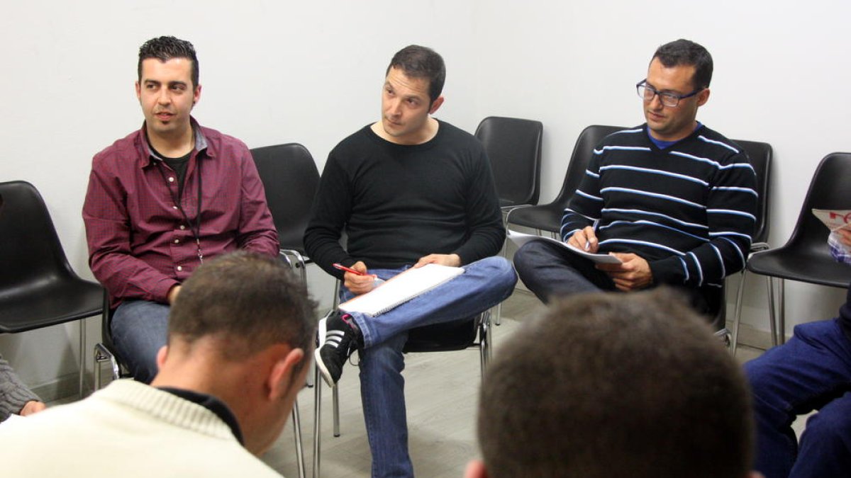 Imatge d'arxiu d'una teràpia de grup de Projecte Home a Tarragona, amb dos usuaris d'esquena i, al fons, el terapeuta del grup i dos usuaris més.