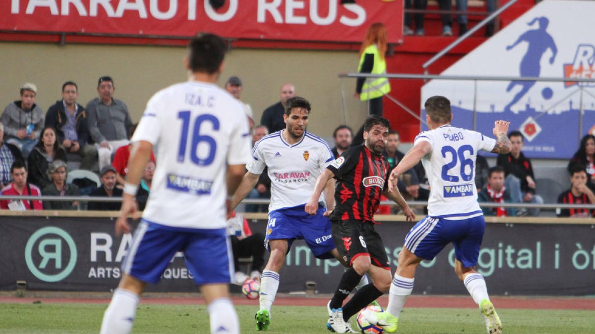 El roig-i-negre Vítor Silva, al centre de la imatge, mira de desfer-se de Pombo, del Saragossa, en un instant del partit de diumenge.