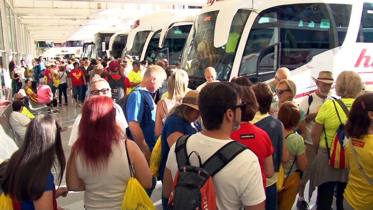 Plano general de ebrenses a punto de subir a los autobuses para ir a Barcelona en la estación de Tortosa, este 11 de septiembre de 2017