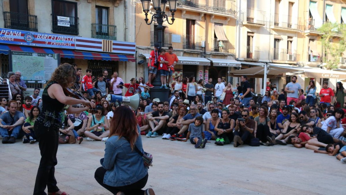 Una violinista toca durant la protesta mentre la resta de manifestants seuen 