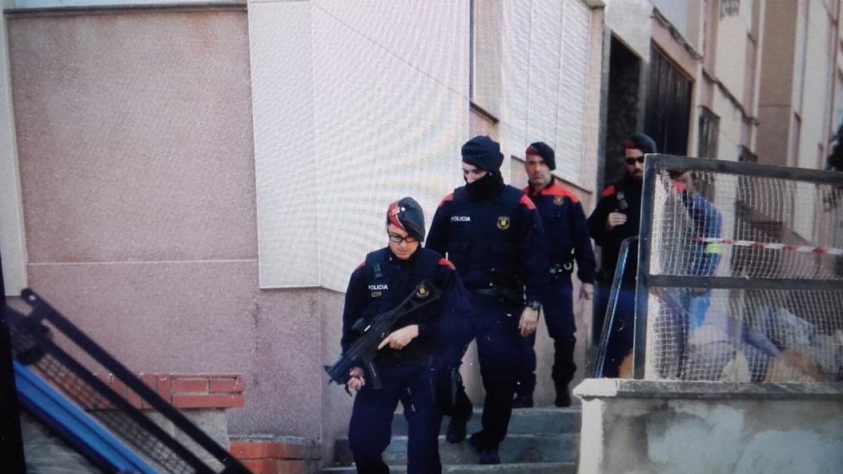 Imatge d'agents dels Mossos d'Esquadra sortint de realitzar un registre en un pis al barri de Sant Salvador.