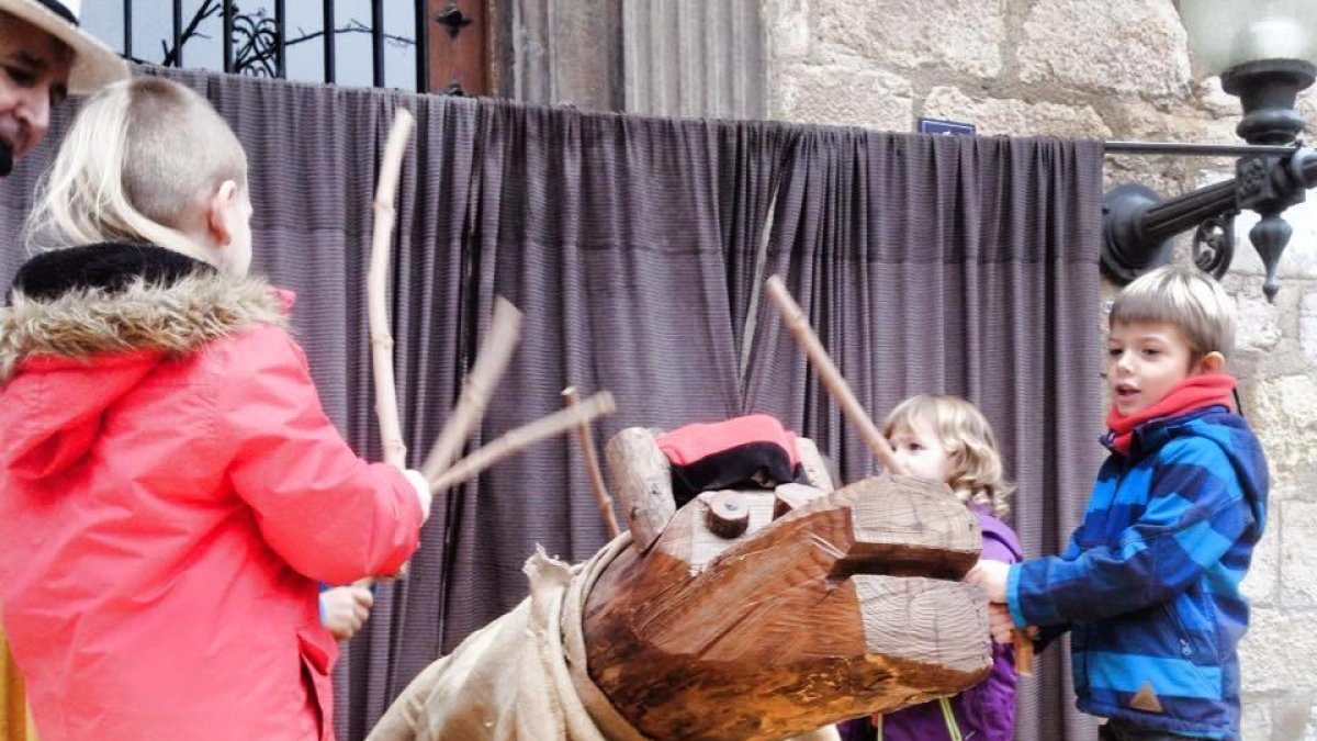 Niños y niñas haciendo cagar el Tió de Montblanc la pasada Navidad.