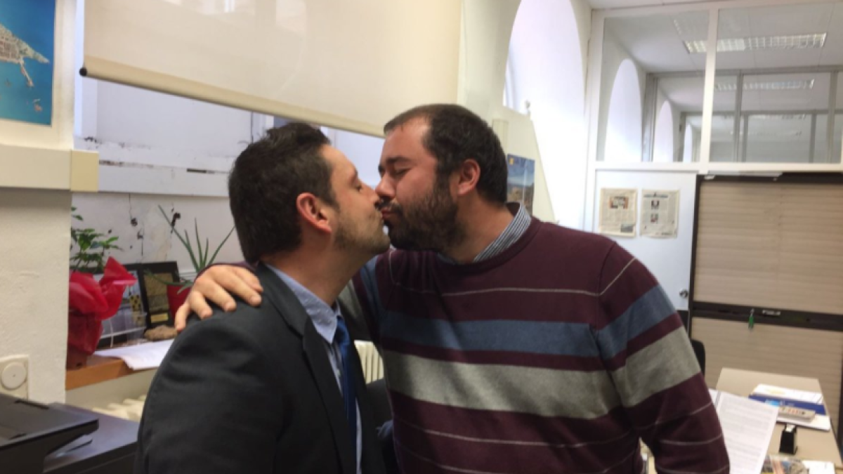 El regidor de Ciutadans, Rubén Viñuales, i el d'ERC, Xavi Puig, fent-se un petó en suport de la iniciativa #matidepetons.