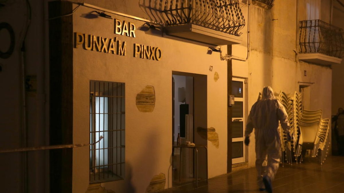 Un agent de la policia científica dels Mossos davant del bar Punxa'm Pinxo de Sant Carles de la Ràpita.