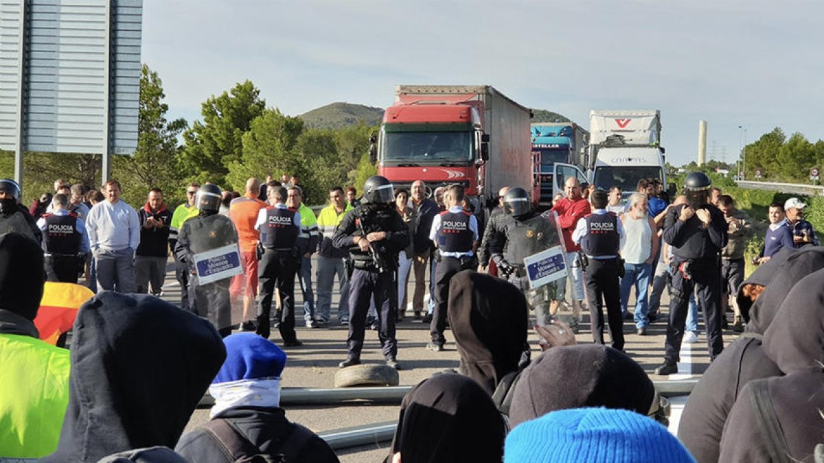 Los Mossos D'Esquadra entre los manifestantes y los conductores parados.
