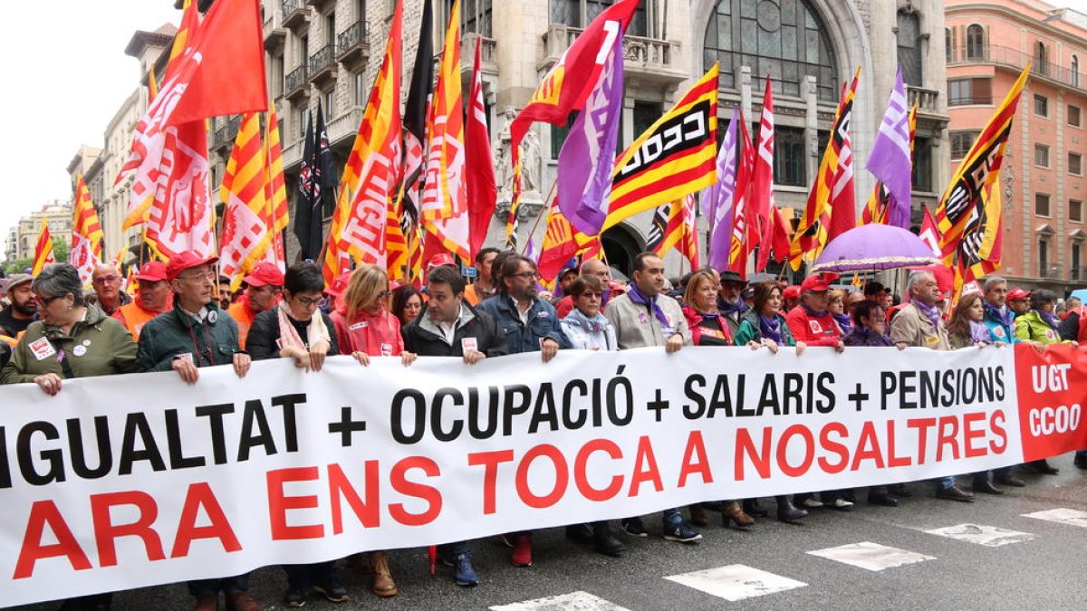 Plano general de la pancarta 'Ahora nos toca a nosotros' de la cabecera de la manifestación de CCOO y UGT del Primero de Mayo.