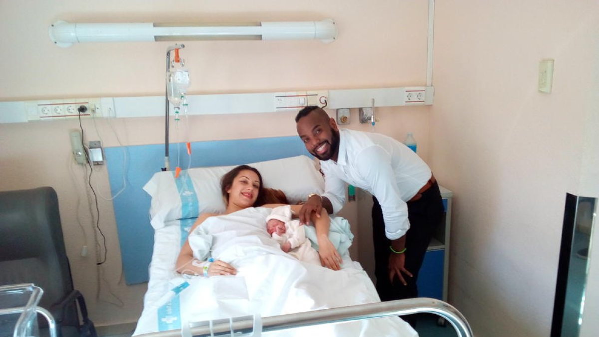 Oyane, la primera tarraconense de este 2018, en brazos de su madre, Naiara, que descansa en la cama del hospital Joan XXIII con la compañía del padre, el Dorian.