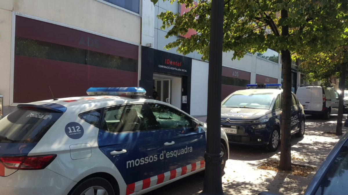Una patrulla dels Mossos d'Esquadra i un furgó de la Policia Nacional davant de la clínica iDental de Tarragona, on realitzen entrades per recollir documentació.