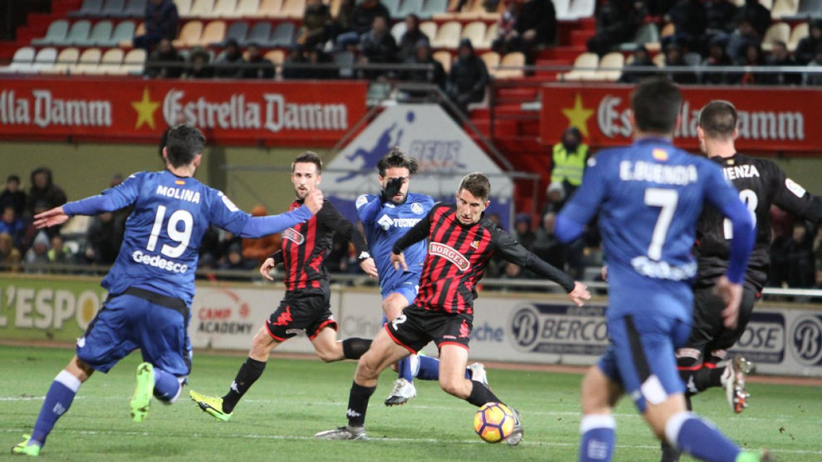 Campins, en el centro, en una acción durante el CF Reus-Getafe, bajo la mirada de Jorge Miramón.