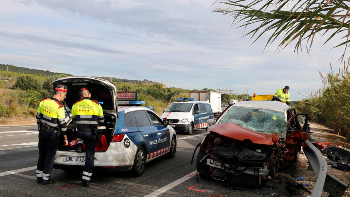 El cotxe de la víctima mortal de l'accident a l'N-340 a Tarragona al costat de dos agents dels Mossos.