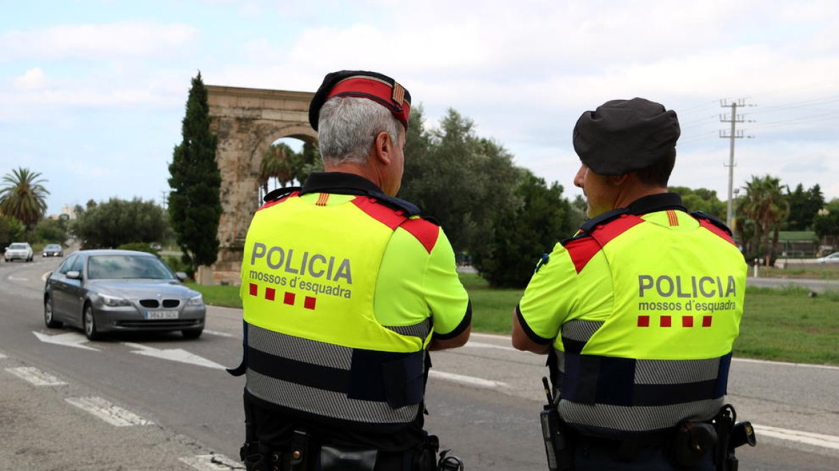 Pla mig de dos agents dels Mossos d'Esquadra en el control informatiu a l'Arc de Berà.