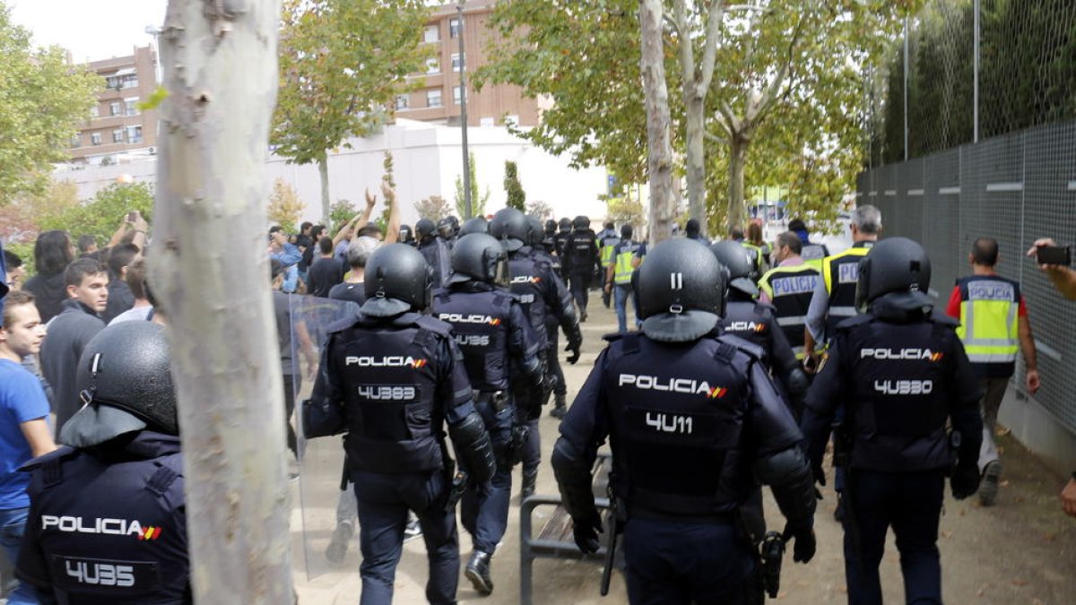 Agents de la policia espanyola marxant amb les urnes de l'IES Ronda de Lleida.