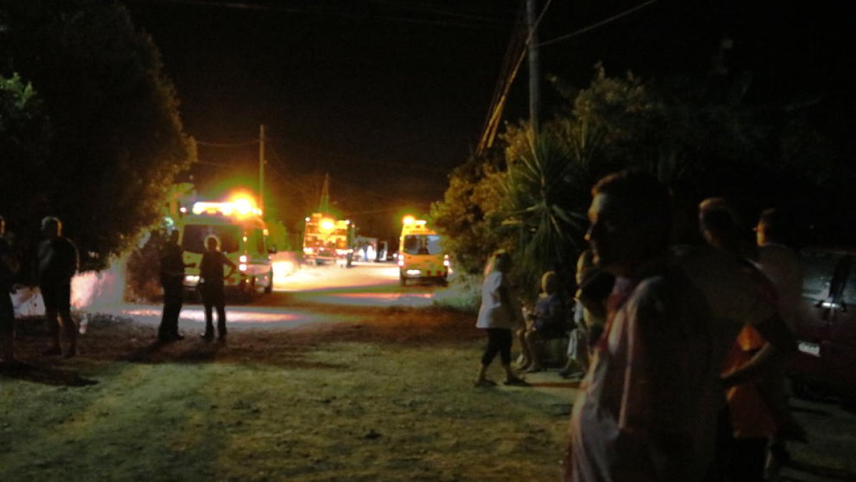 Vecinos en el lateral esperando ante el perímetro de seguridad con los vehículos de emergencia por la explosión de una casa a la urbanización Montecarlo en Alcanar Platja, este 17 de agosto de 2017