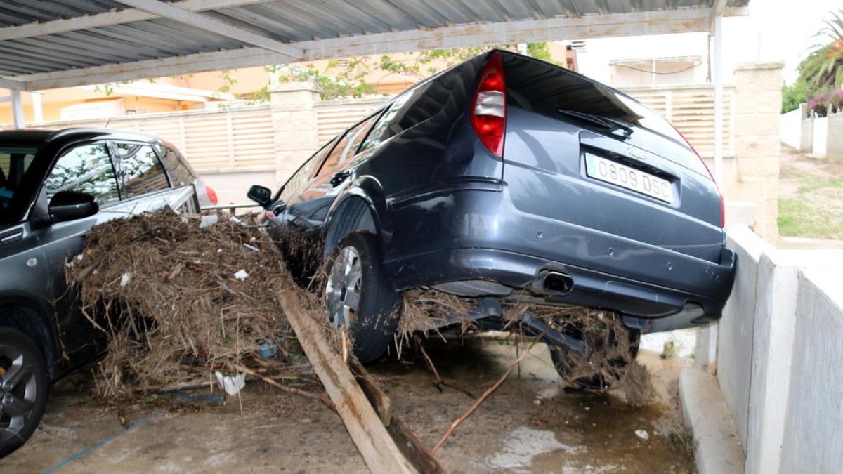 Un vehicle encastat en el garatge d'una propietat de la urbanització Serramar d'Alcanar Platja.