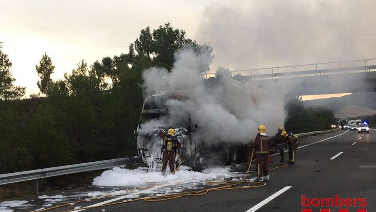 Els Bombers apagant el foc, que s'ha originat a la cabina del camió.