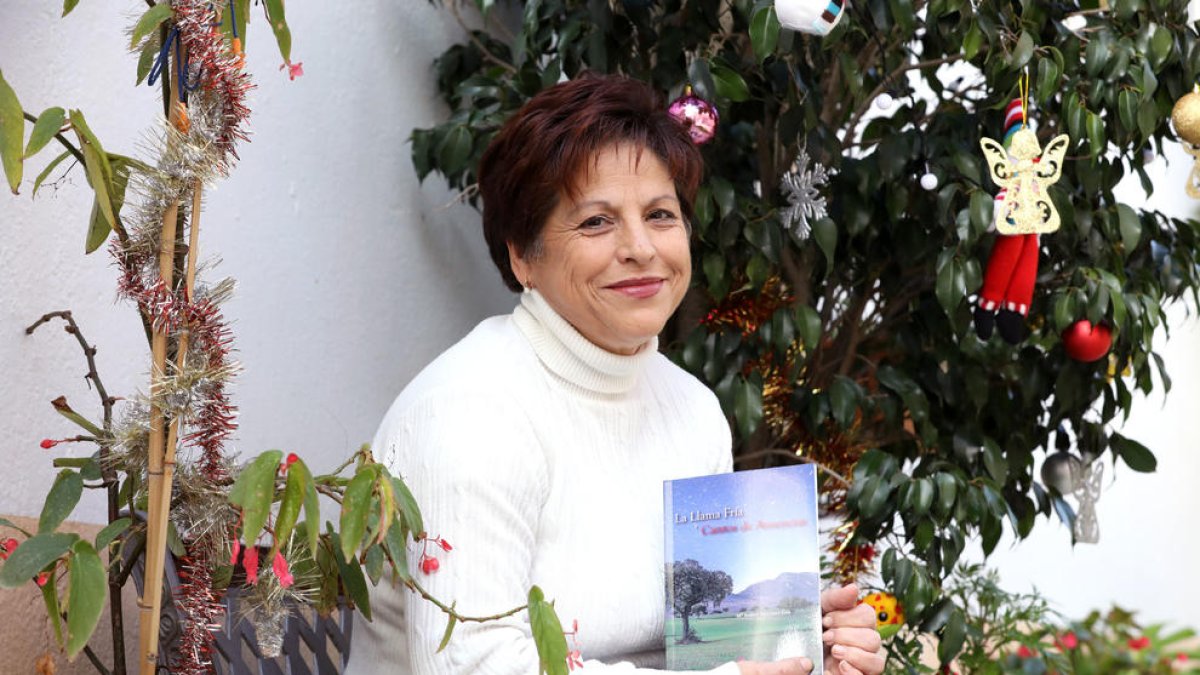 Maria Isabel a l'entrada de casa seva, amb el seu primer llibre, 'La Llama Fría y Cantos de Ausencias'.