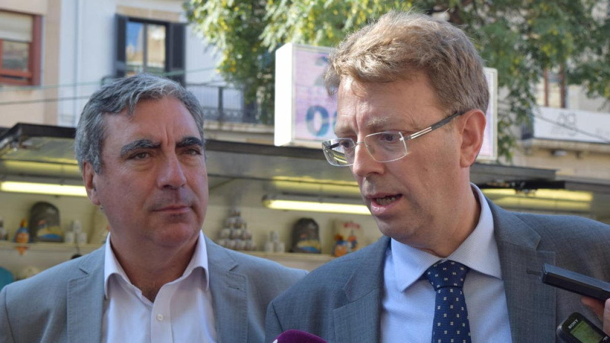 Ferran Bel, acompanyat per Albert Abelló, durant la roda de premsa d'aquest matí davant la parada de marxandatge dels Jocs ubicada a la Rambla Nova.