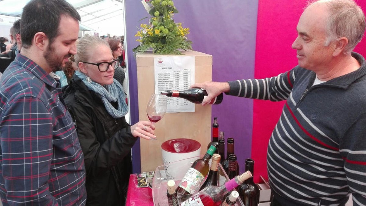 Un hombre sirve copas de vino DO Terra Alta en una paradade la Fiesta del Vino de Gandesa.