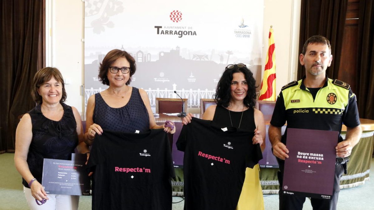 Plano general de la presentación de la campaña 'Respecta'm' durante las fiestas del 2017 en el Ayuntamiento de Tarragona, con la concejala Ana Santos mostrando una camiseta con el lema.