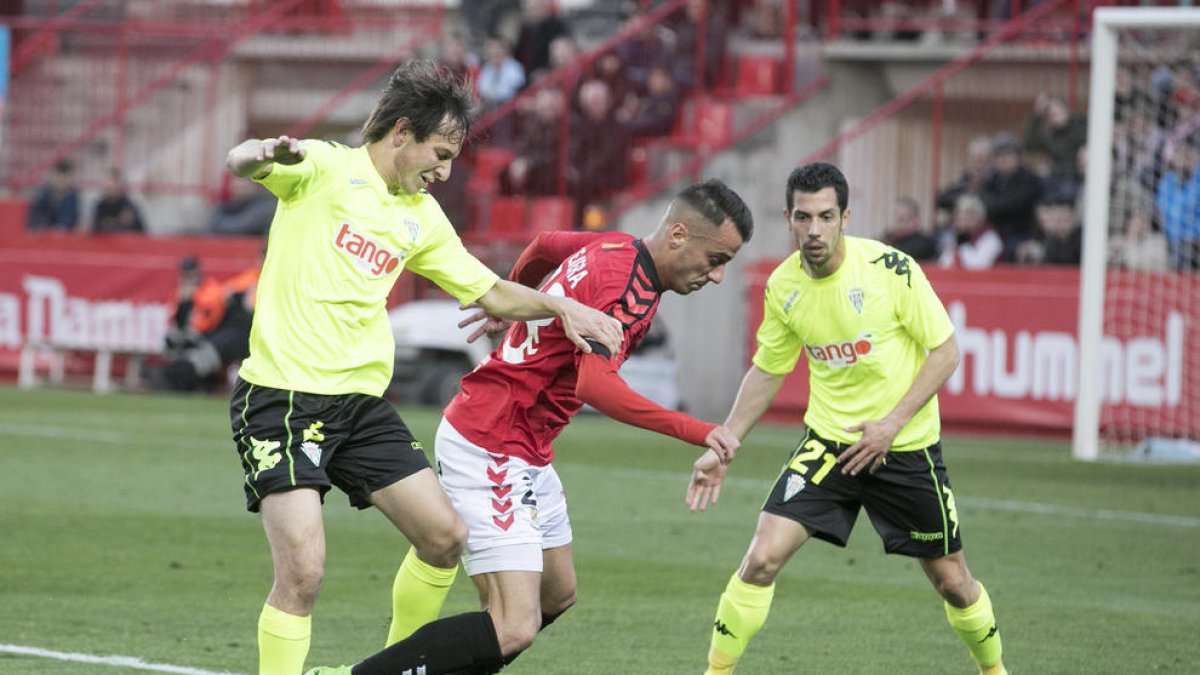 Sergio Tejera intenta sortear a dos rivales durante el duelo que el Nàstic disputó contra la Córdoba en el Nou estadi.