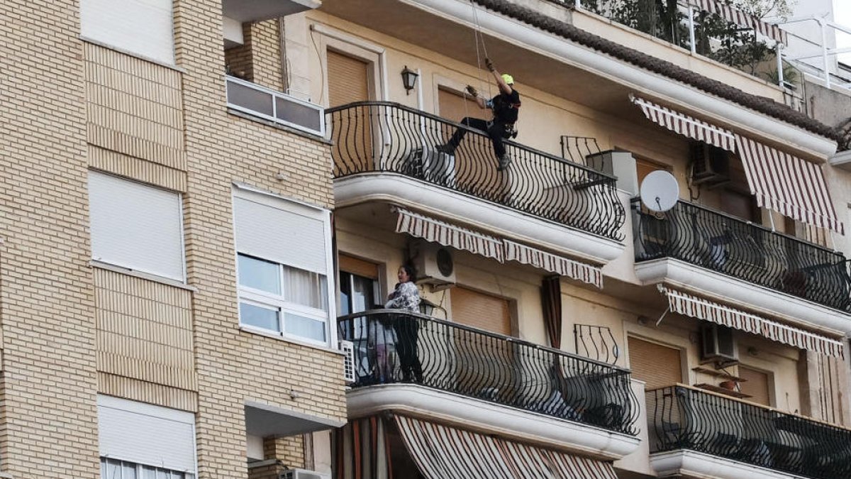 El policía acercándose al balcón, donde había la mujer con sus dos hijos.