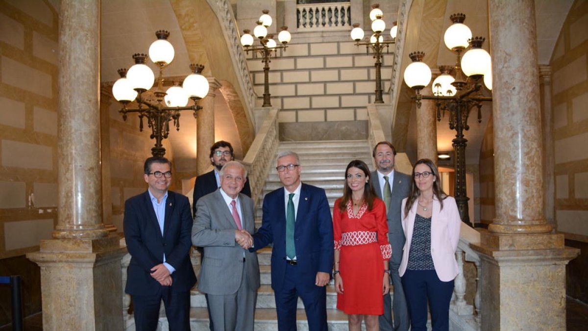 Fotografía de familia de la reunión, con el alcalde de Miami y Ballesteros encajando las manos.