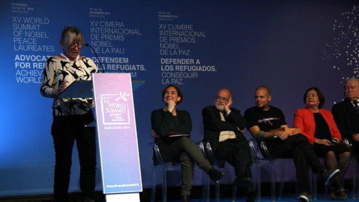 Jody Williams llegint la declaració dels Nobels de la Pau a Barcelona, mentre l'escolten Ada Colau, Aracadi Oliveres, René Pérez i Lech Walesa , el 15 de novembre de 2015 (horitzontal)