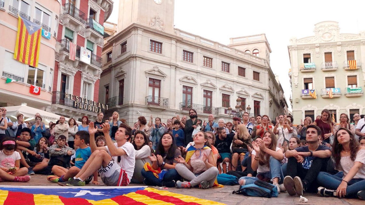 Una estelada estirada a terra davant dels ciutadans que segueixen des de la plaça del Mercadal de Reus la compareixença del president Carles Puigdemont.