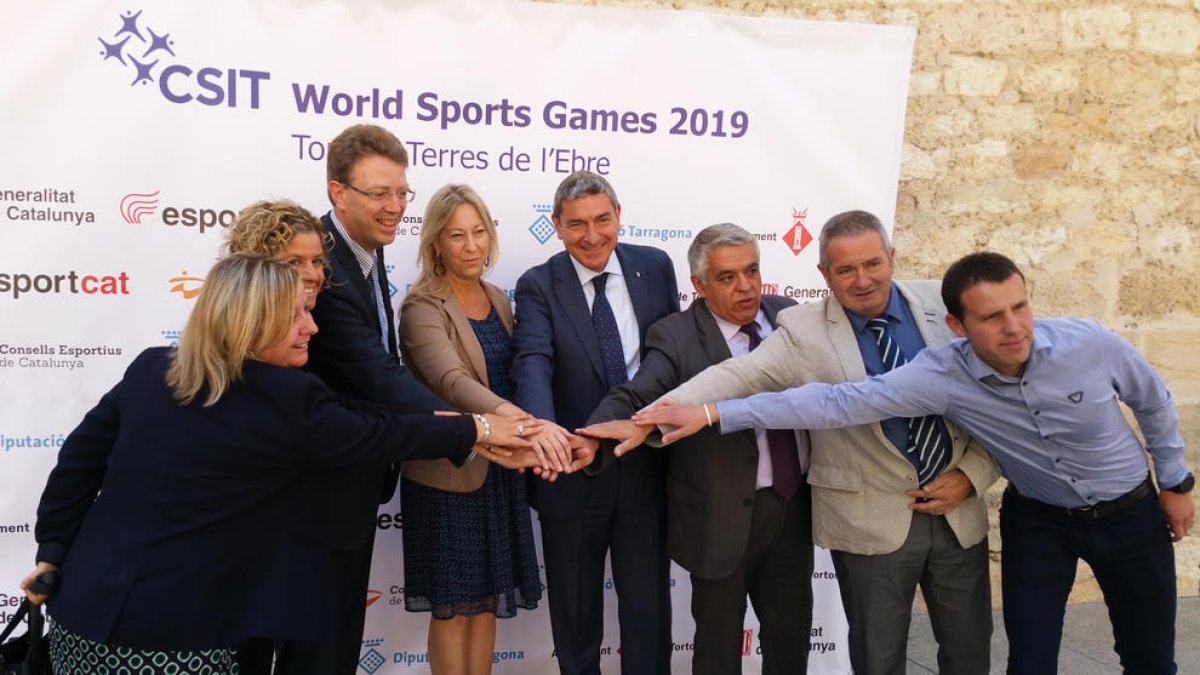 La consellera de Presidència, Neus Munté, i l'alcalde de Tortosa, Ferran Bel, entre altres, ajunten les mans en la presentació dels CSIT World Games. Imatge del 20 de maig de 2017