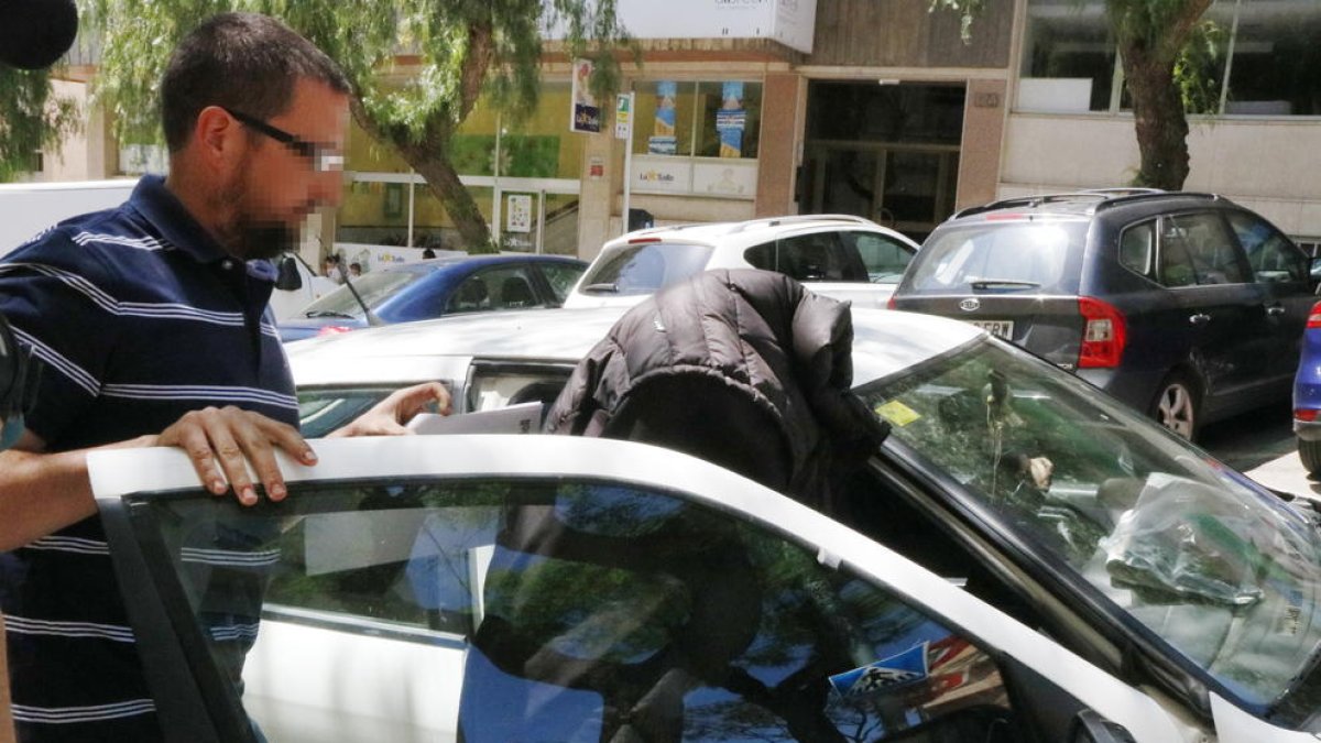 La exmonitora del jardín de infancia del Morell entrando con la cara tapada a un vehículo después de comparecer en el juzgado de guardia de Tarragona.