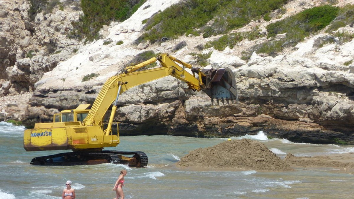 La máquina llevando a cabo los trabajos de reposición de arena de la playa Llarga.