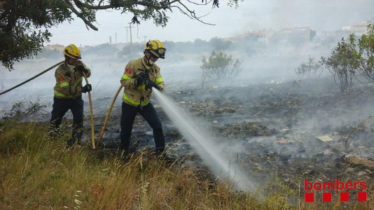 Els bombers, remullant la zona de l'incendi a La Canonja.