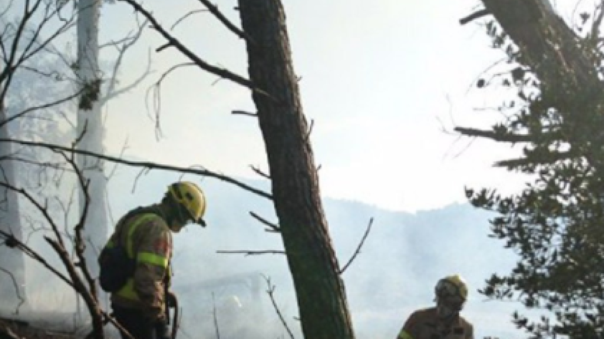 Dos bomberos apagando uno de los fuegos de Alforja.