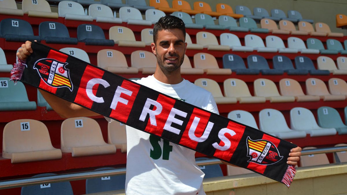 El futbolista amb la bufanda roig-i-negre durant la seva presentació a l'Estadi Municipal.