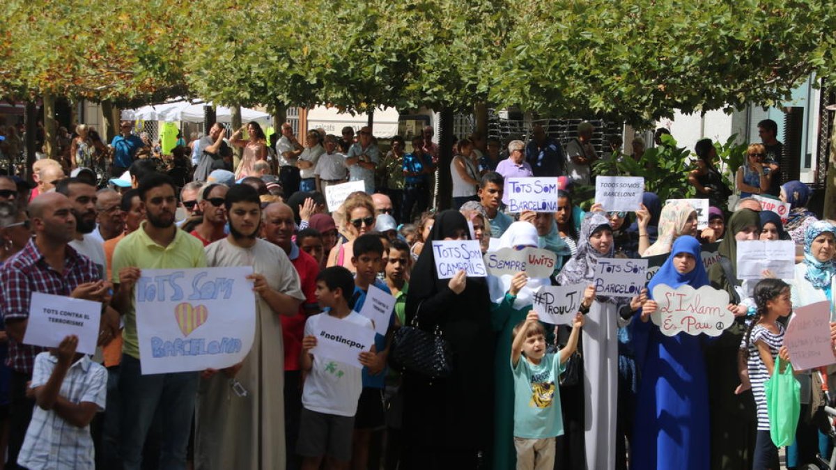 Pla obert de diversos manifestants musulmans a Valls, amb pancartes, en la concentració a Valls. Imatge del 26 d'agost de 2017