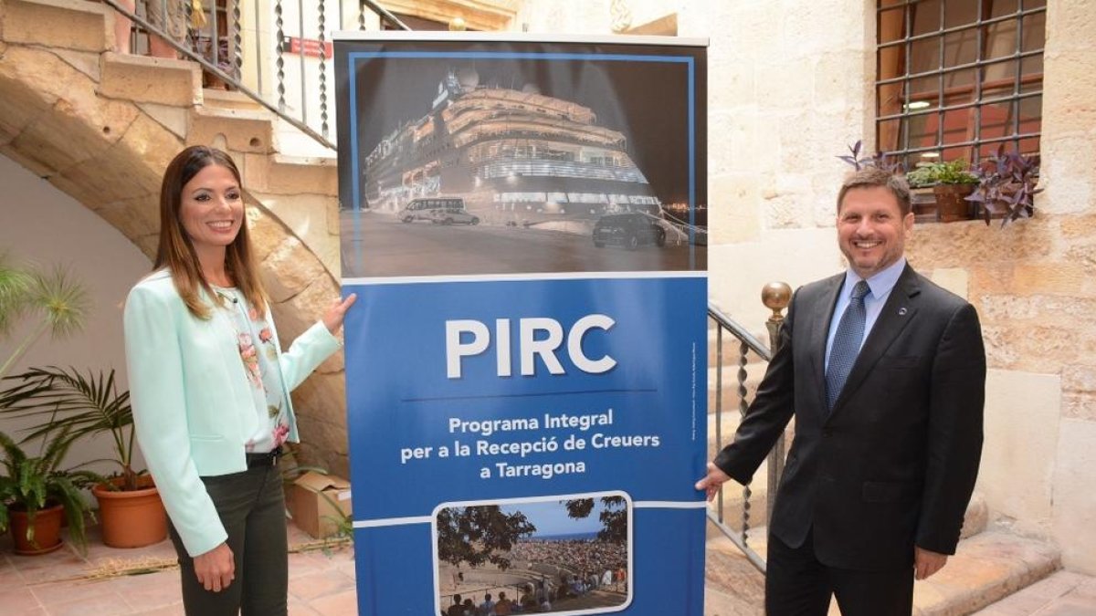 La regidora de Turisme de l'Ajuntament de Tarragona, Inma Rodríguez, i el president del Port de Tarragona, Josep Andreu, davant un cartell promocional del Programa integral per a la recepció de creuers, el 30 de maig del 2017.