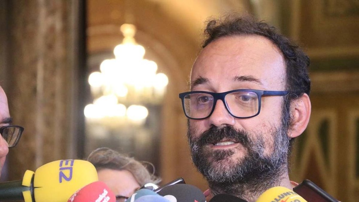 El diputado de la CUP Benet Salellas atiende los medios en los pasillos|pasadizos del Parlamento